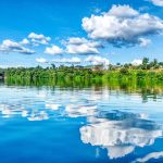 The wide River Nile flowing between green banks